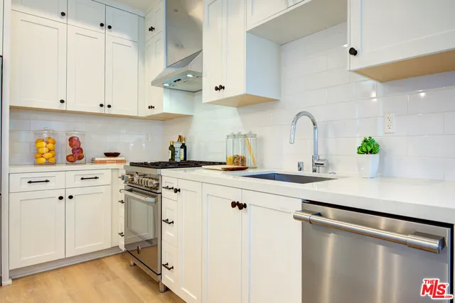 a kitchen with cabinets appliances a sink and a counter space