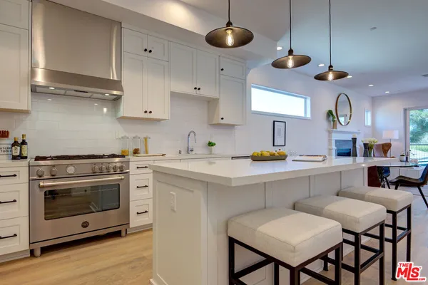 a kitchen with stainless steel appliances a stove a sink and a refrigerator