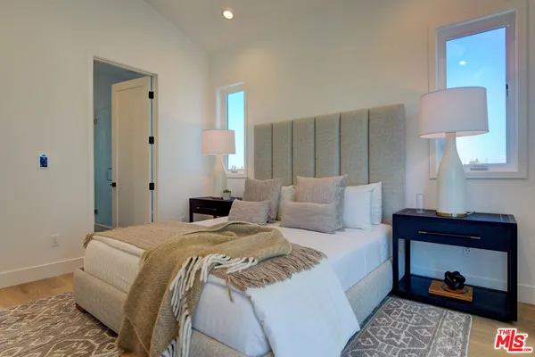 a bedroom with a bed and a lamp on dresser