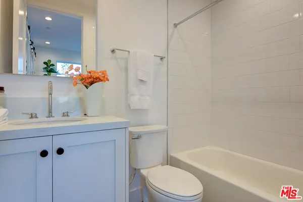 a bathroom with a sink mirror toilet and bathtub