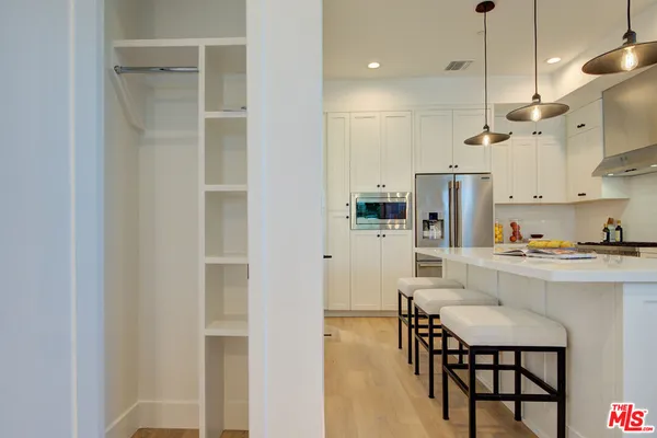 a kitchen with stainless steel appliances kitchen island a refrigerator and a dining table