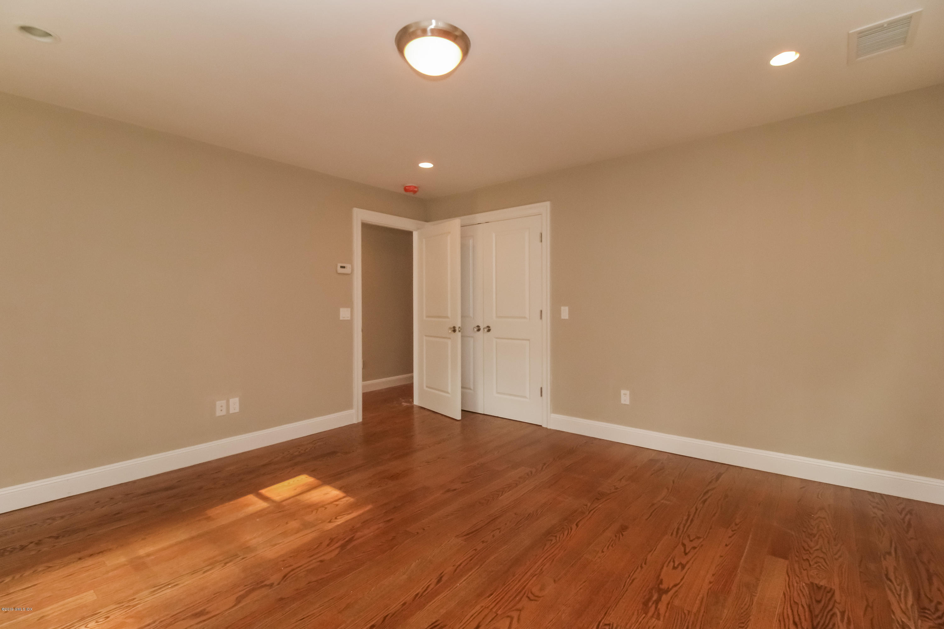54 Dandy Drive Cos Cob, CT 06807 - Photo 29 of 35 a view of an empty room with wooden floor and a window