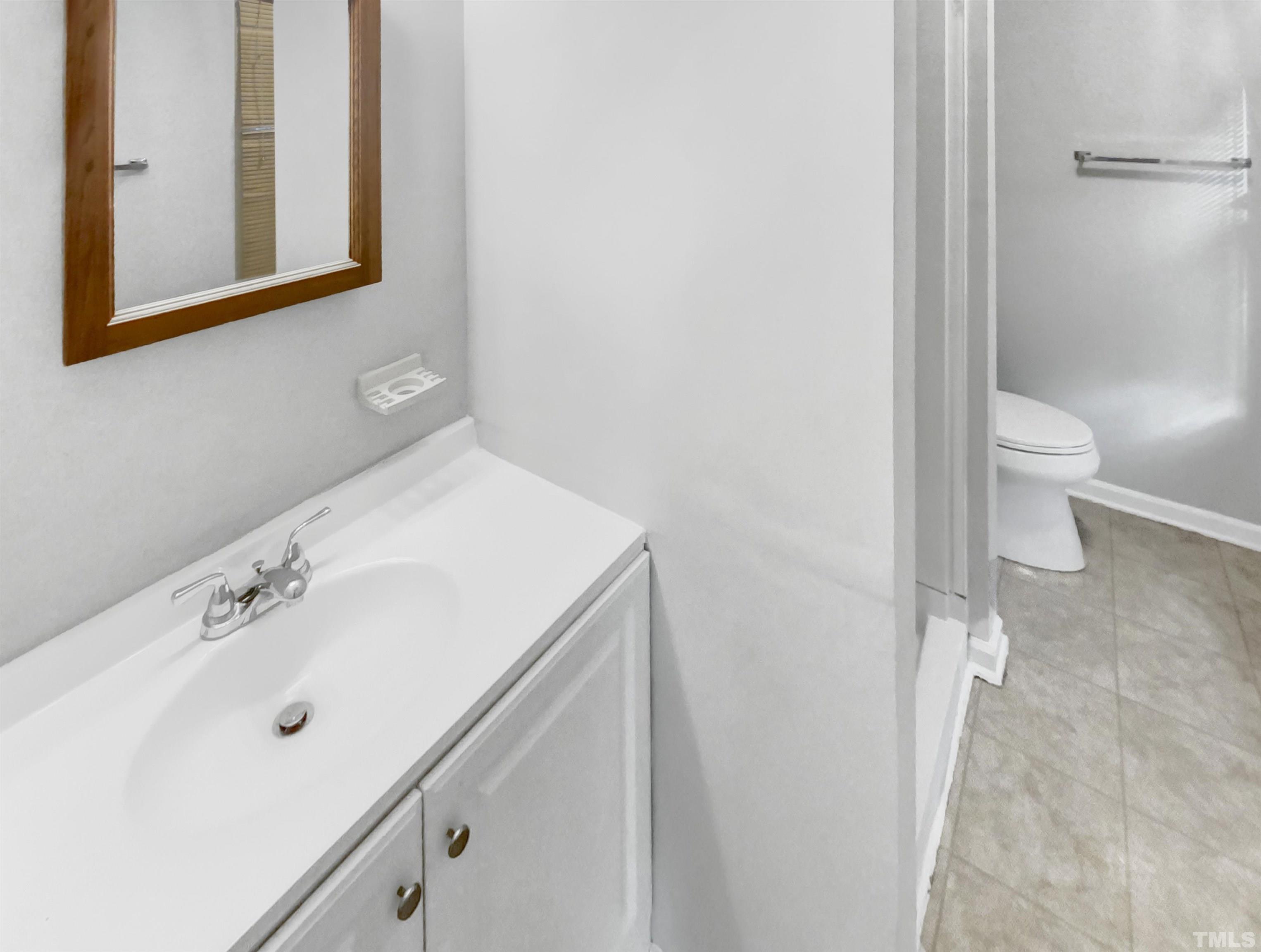 2404 Tusket Court Raleigh, NC 27613 - Photo 15 of 19 a bathroom with a sink a toilet and shower