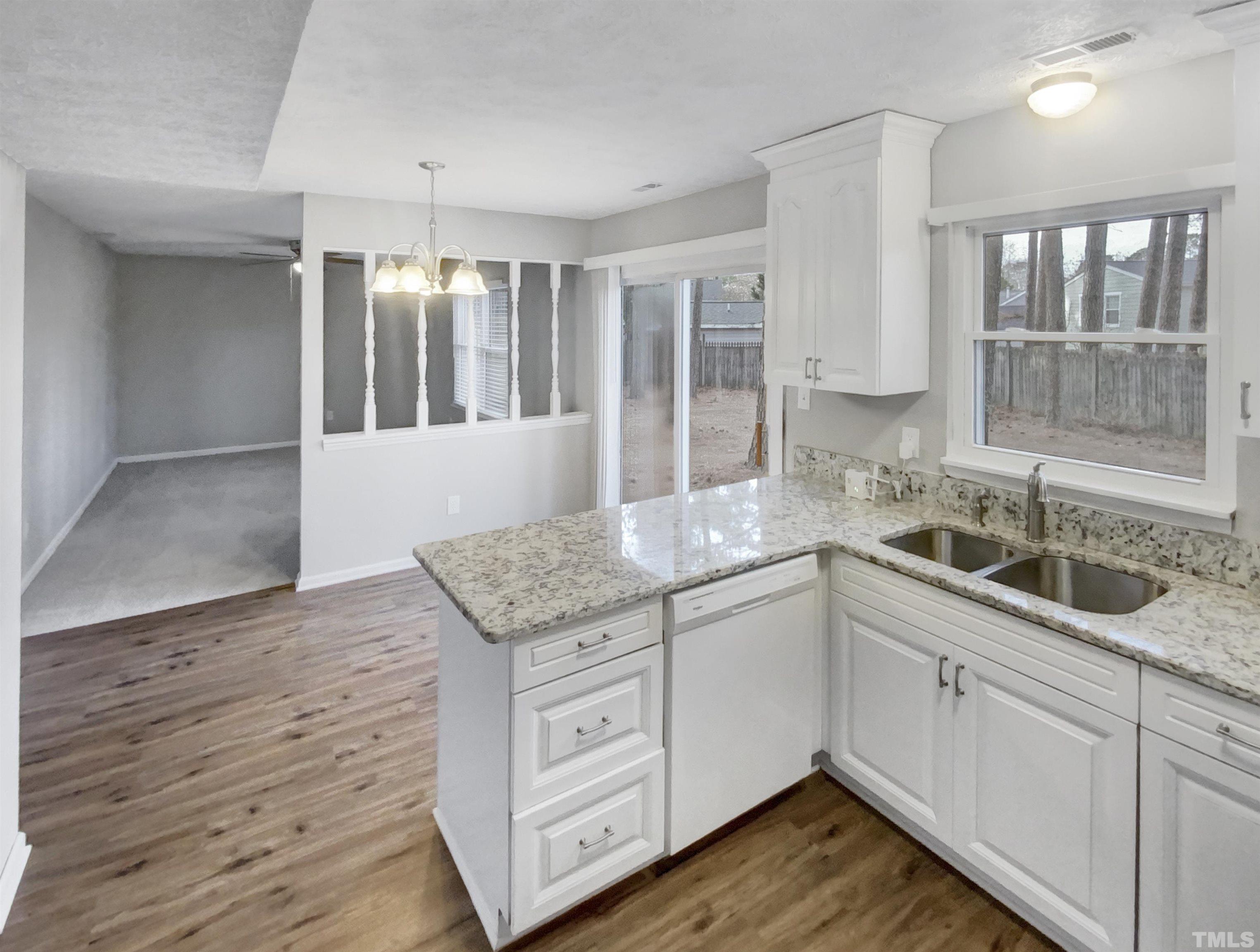2404 Tusket Court Raleigh, NC 27613 - Photo 7 of 19 a kitchen with sink cabinets and wooden floor