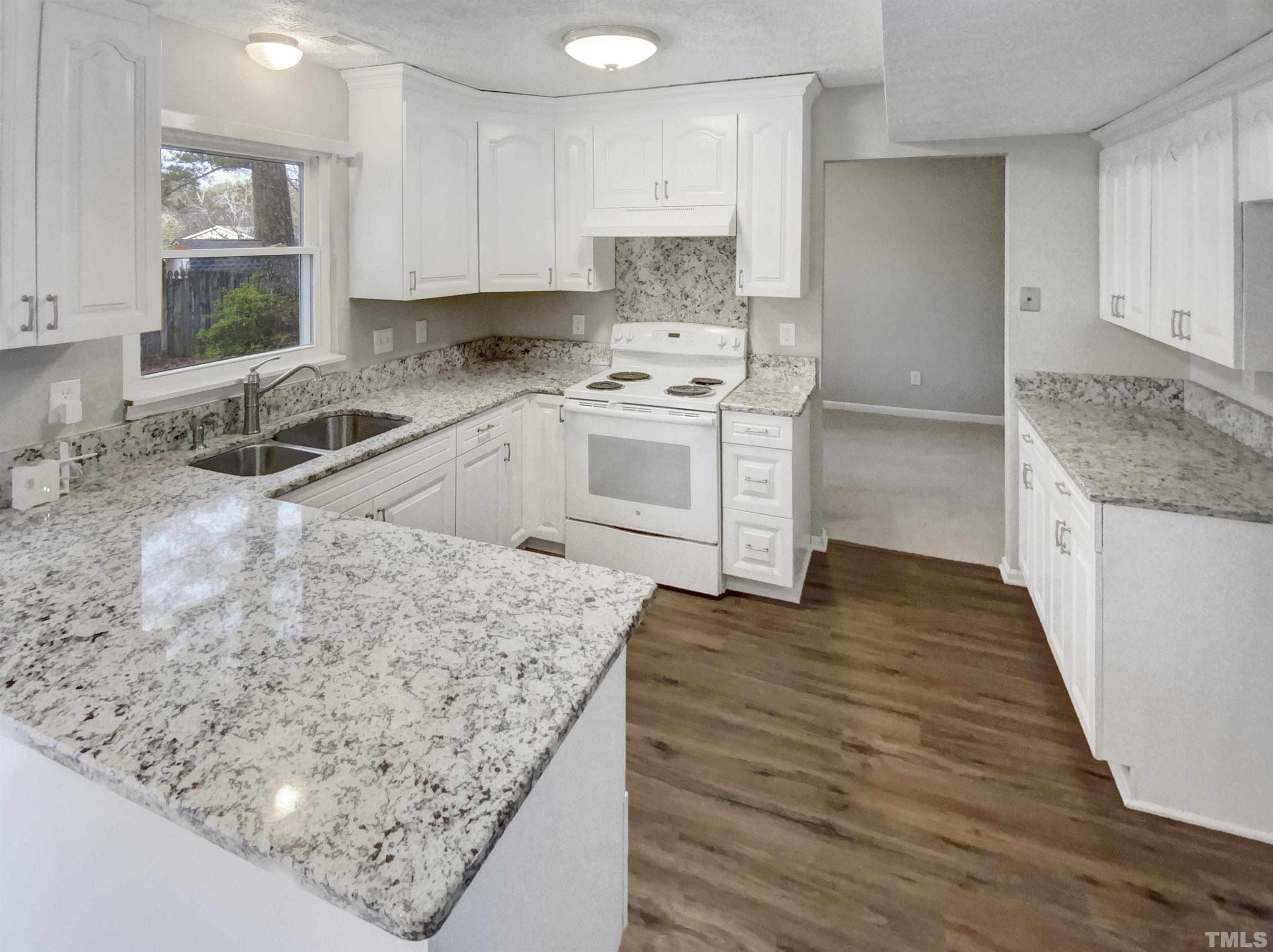 2404 Tusket Court Raleigh, NC 27613 - Photo 10 of 19 a kitchen with stainless steel appliances granite countertop a sink stove and white cabinets