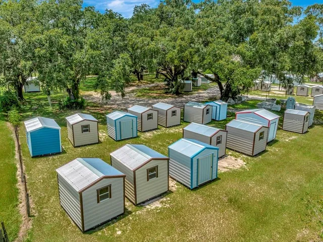 an aerial view of a residential houses with yard and lake view