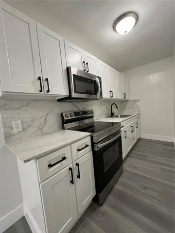 a kitchen with stainless steel appliances granite countertop a sink and a stove
