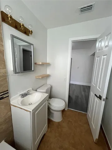 a bathroom with a sink a toilet and a mirror