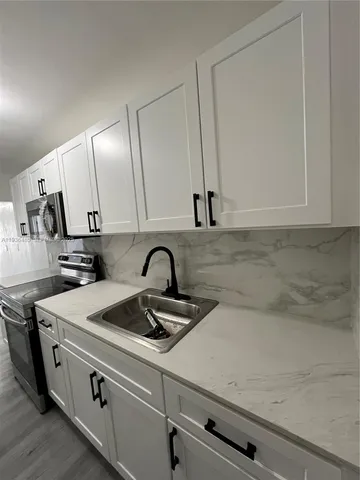 a kitchen with a sink cabinets and appliances
