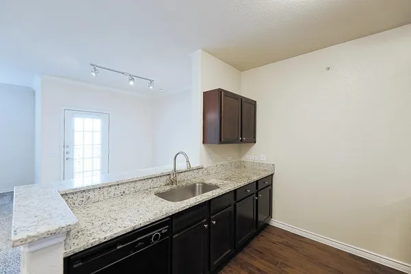 a bathroom with a granite countertop sink a mirror and wooden cabinets