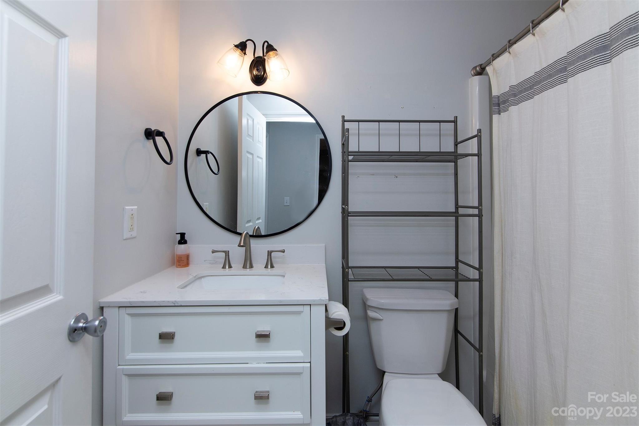 210 Church Street Locust, NC 28097 - Photo 12 of 22 a bathroom with a sink mirror vanity and toilet