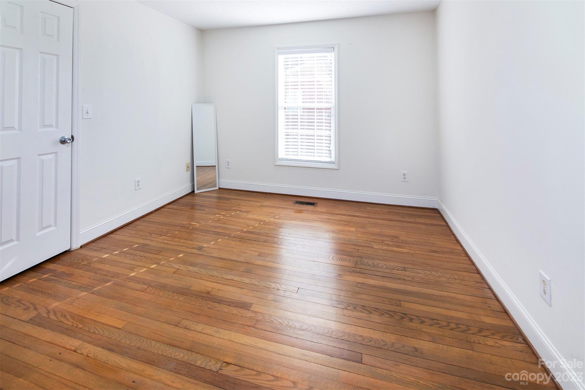 210 Church Street Locust, NC 28097 - Photo 17 of 22 a view of an empty room with wooden floor and a window