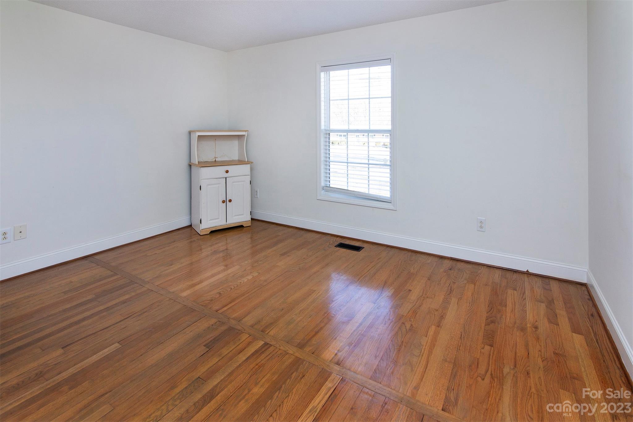 210 Church Street Locust, NC 28097 - Photo 18 of 22 an empty room with wooden floor and windows