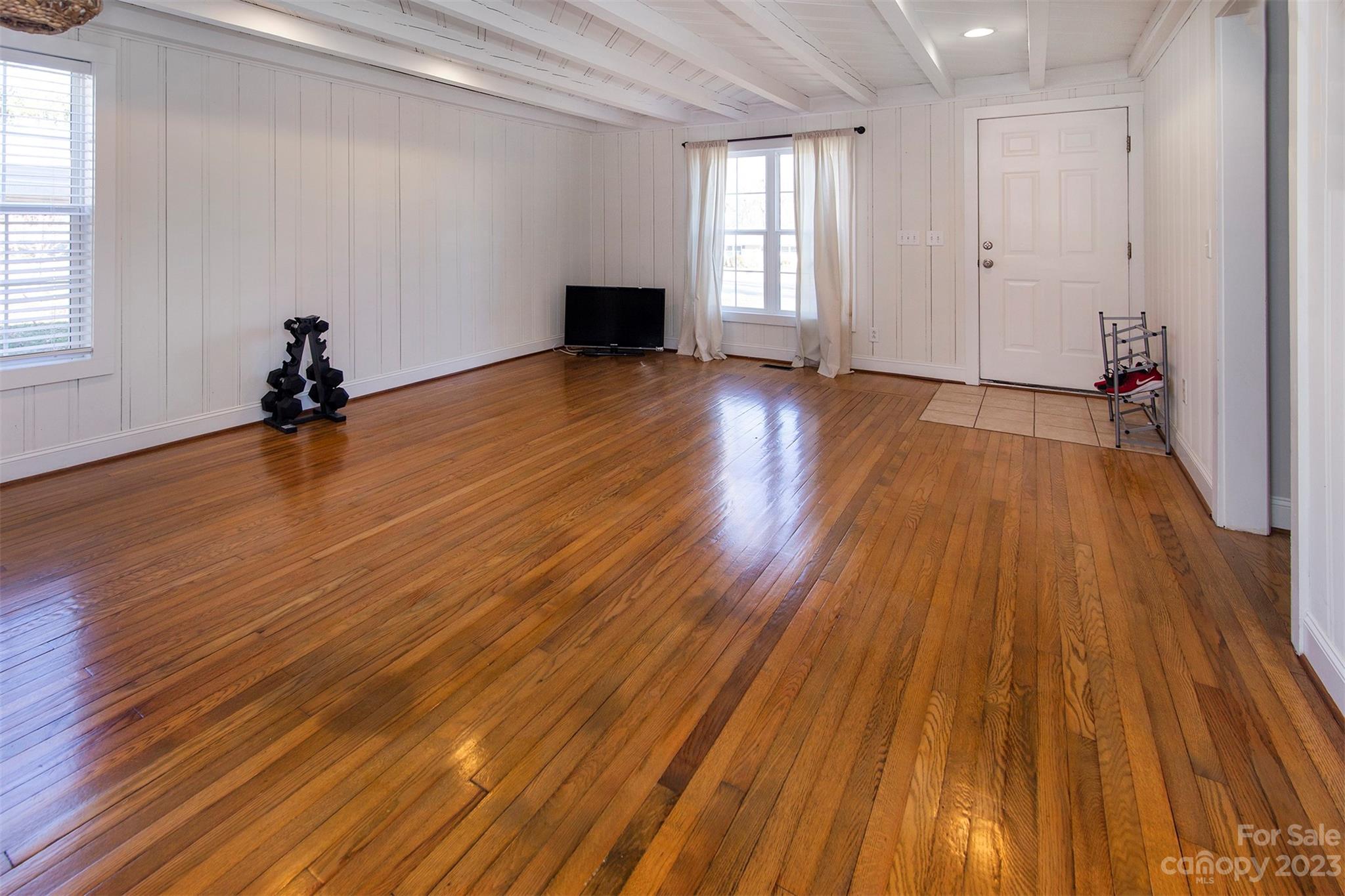 210 Church Street Locust, NC 28097 - Photo 9 of 22 a view of an empty room with wooden floor and a window