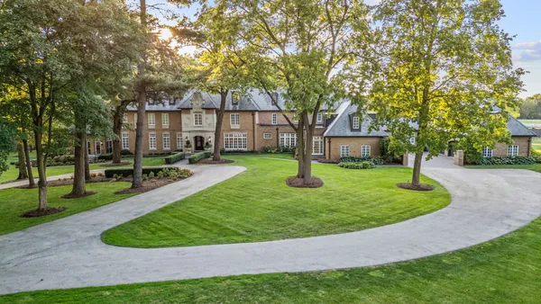 a view of a house with backyard and trees