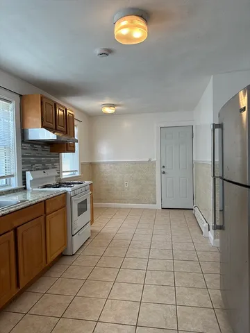 a kitchen with stainless steel appliances granite countertop a refrigerator and a stove top oven