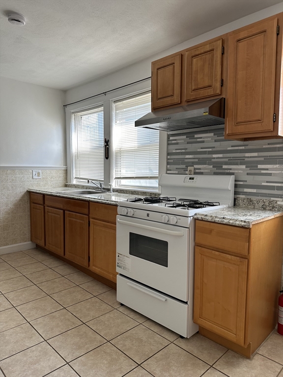 41 Flynt Street, Unit 1F Quincy, MA 02171 - Photo 12 of 21 a kitchen with stainless steel appliances granite countertop a stove a sink and a microwave