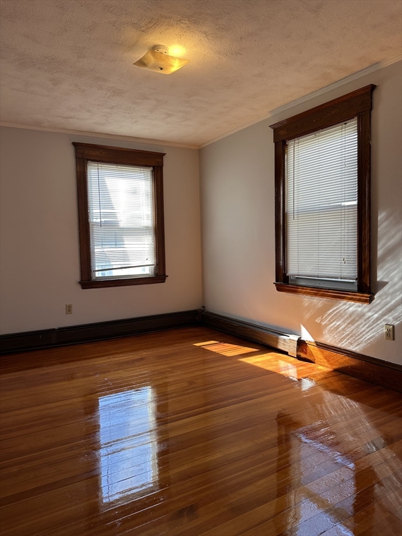 41 Flynt Street, Unit 1F Quincy, MA 02171 - Photo 20 of 21 a view of an empty room with wooden floor and a window