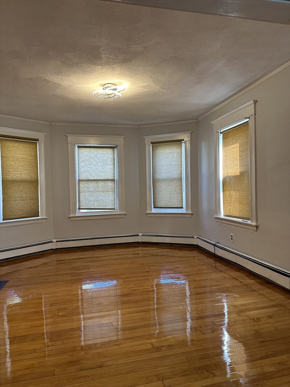 41 Flynt Street, Unit 1F Quincy, MA 02171 - Photo 6 of 21 a view of an empty room with window and wooden floor