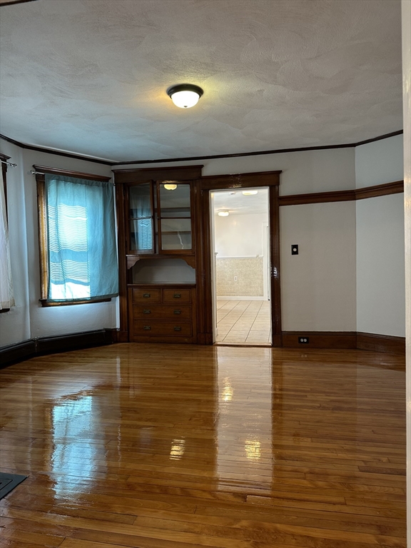 41 Flynt Street, Unit 1F Quincy, MA 02171 - Photo 9 of 21 a view of an empty room with window and wooden floor