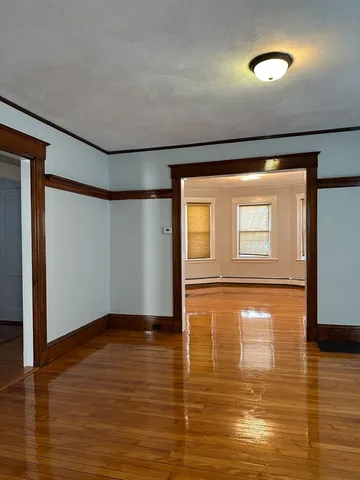 a view of empty room with wooden floor