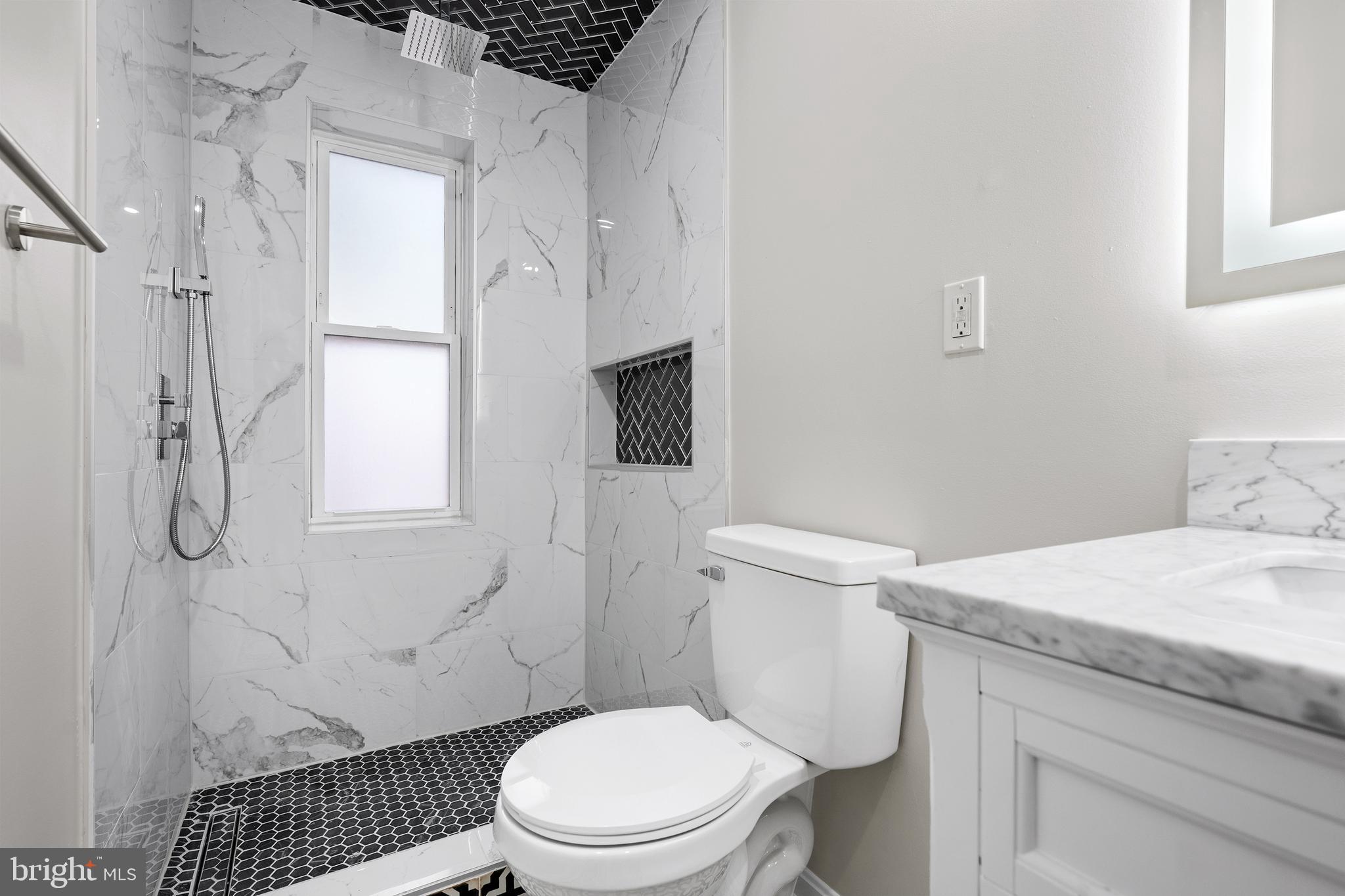 1358 Towson Street Baltimore, MD 21230 - Photo 20 of 39 a bathroom with a granite countertop toilet sink and shower