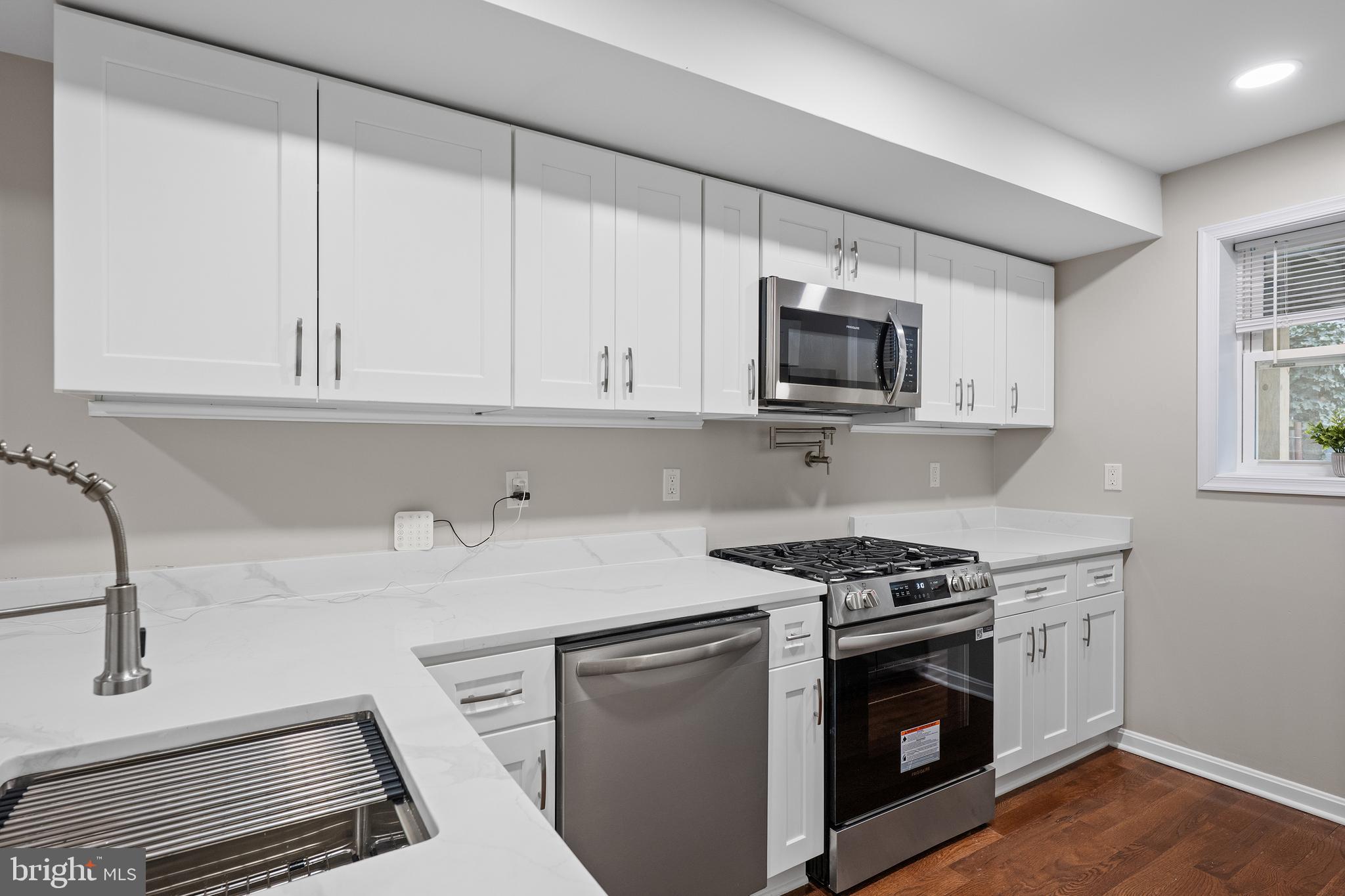 1358 Towson Street Baltimore, MD 21230 - Photo 10 of 39 a kitchen with granite countertop a sink stove and microwave