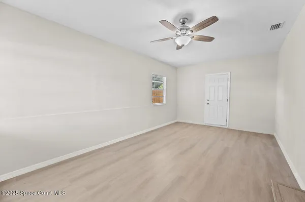 an empty room with closet and ceiling fan