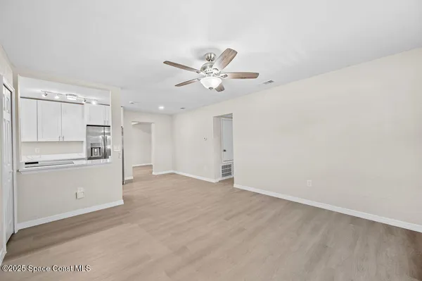 a view of an empty room with closet and a ceiling fan