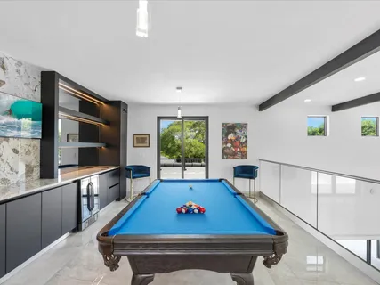 a living room with furniture pool table and a large window