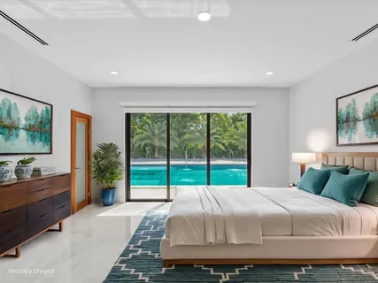 a bedroom with a bed and a dresser next to a window