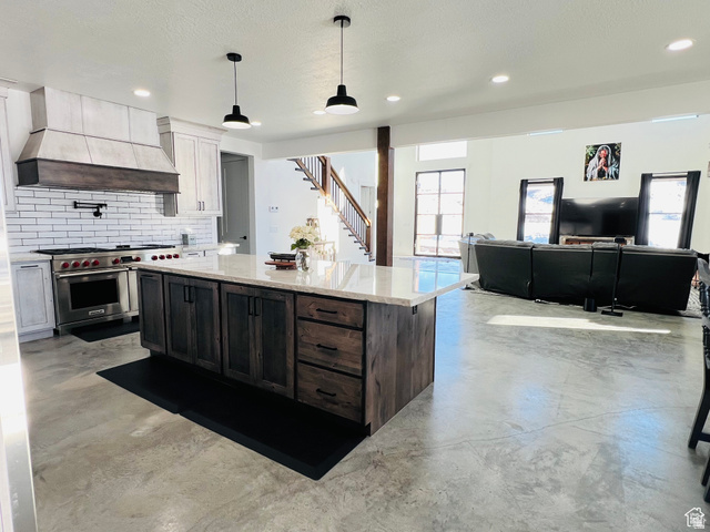 100 Whit Lane Georgetown, ID 83239 - Photo 75 of 76 Kitchen featuring finished concrete flooring, light stone countertops, double oven range, a center island, and open floor plan