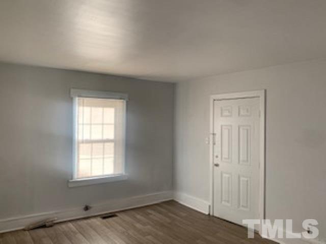 1704 Robinhood Road Durham, NC 27701 - Photo 4 of 18 an empty room with wooden floor and window