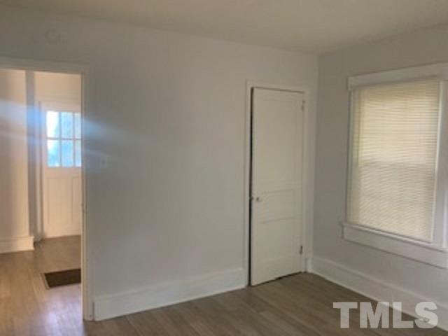 1704 Robinhood Road Durham, NC 27701 - Photo 8 of 18 an empty room with wooden floor cabinet and windows