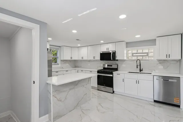 a large kitchen with cabinets stainless steel appliances and a sink