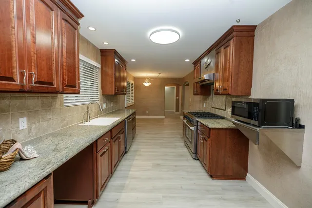 a spacious bathroom with a granite countertop sink mirror and toilet