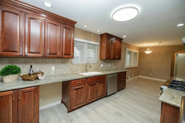a view of an empty room with a kitchen and a fireplace