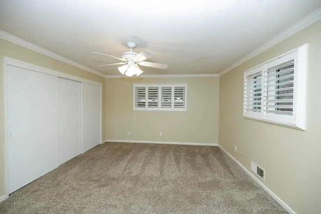front view of a house with a yard and palm trees