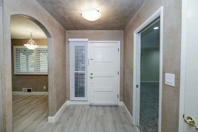 a big room with fireplace chandelier and windows