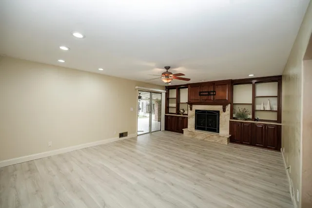 an empty room with wooden floor and mirror