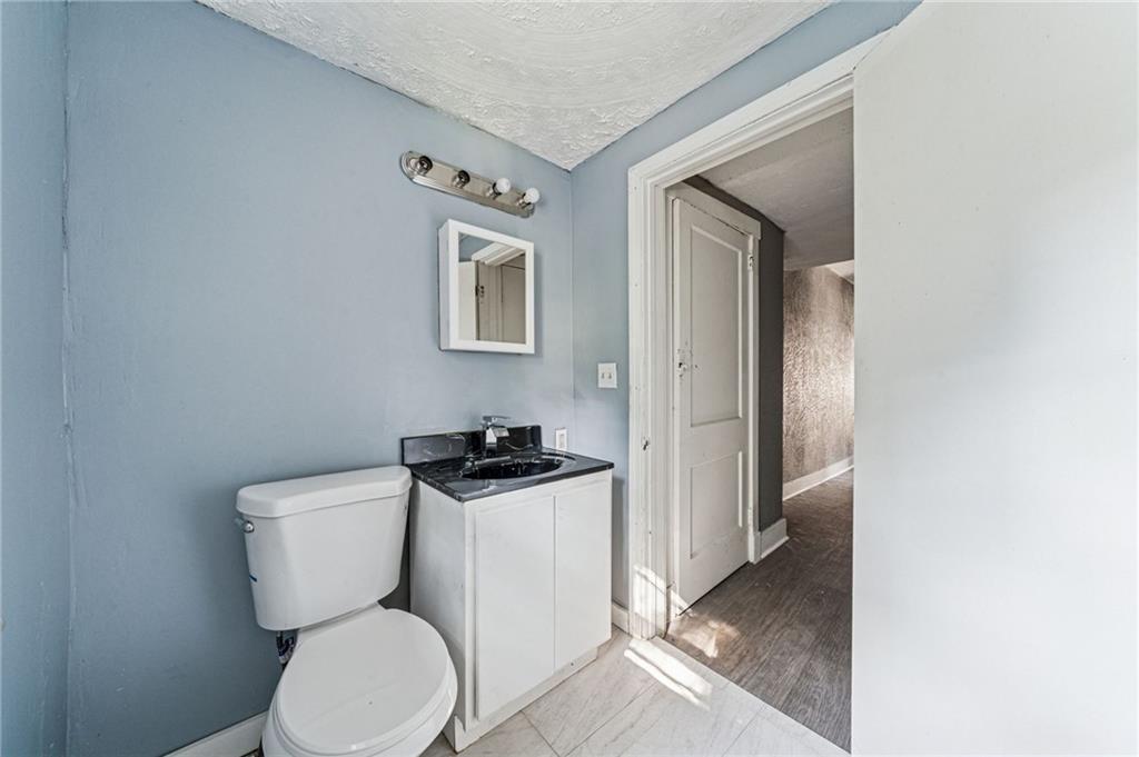 214 Fleet Street Braddock, PA 15104 - Photo 16 of 31 a bathroom with a toilet a sink and mirror
