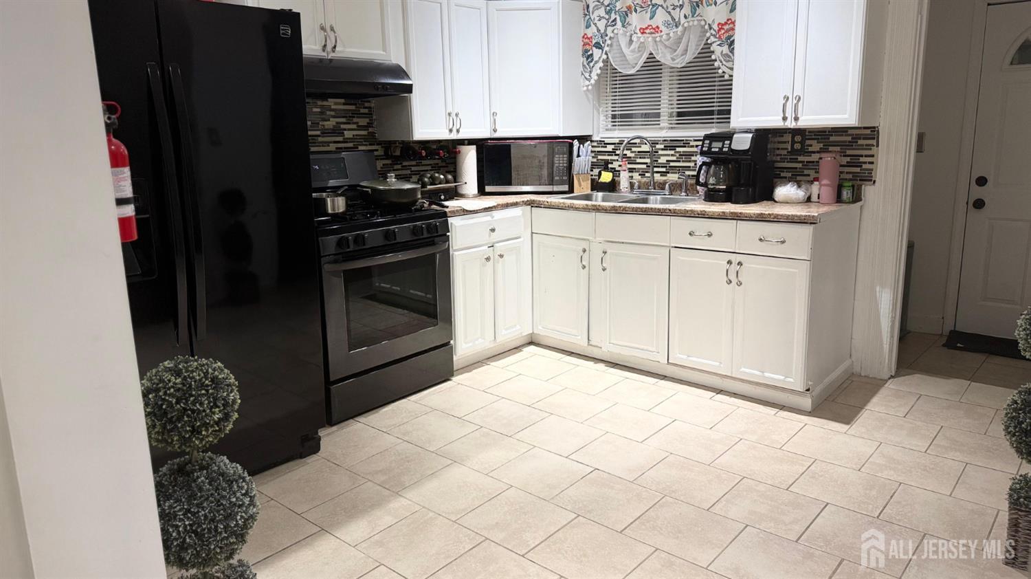 283 Washington Street Perth Amboy, NJ 08861 - Photo 2 of 15 a kitchen with stainless steel appliances kitchen island granite countertop a refrigerator and a stove
