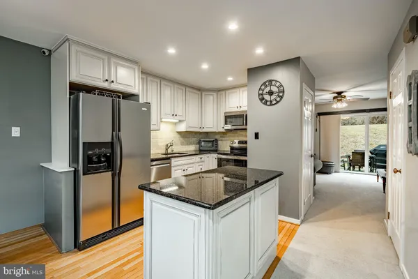 a kitchen with granite countertop a refrigerator and a sink