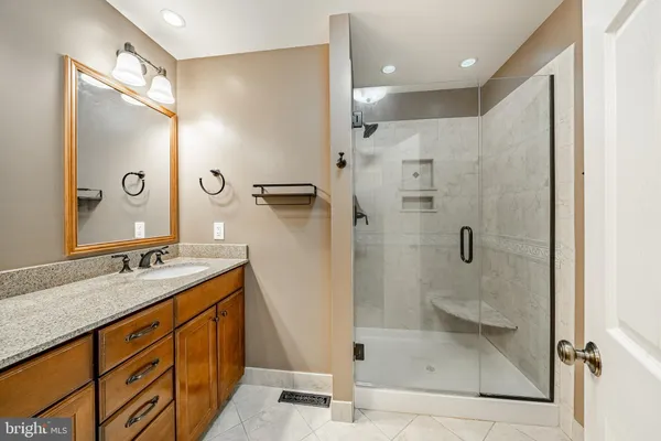 a bathroom with a granite countertop sink mirror shower and