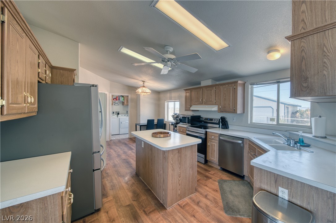 2931 Rio Rancho Drive, Unit 4 Pahrump, NV 89048 - Photo 7 of 21 A well-equipped kitchen features an island, stainless steel appliances, and ample cabinetry for storage.