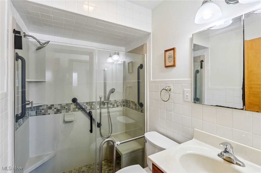 970 Eastern Road Doylestown, OH 44230 - Photo 26 of 49 Bathroom with vanity, a shower stall, and tile walls