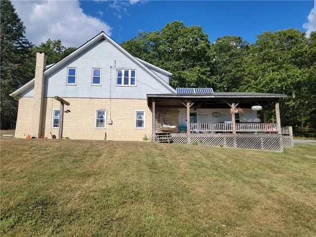 a view of a house with pool and chairs