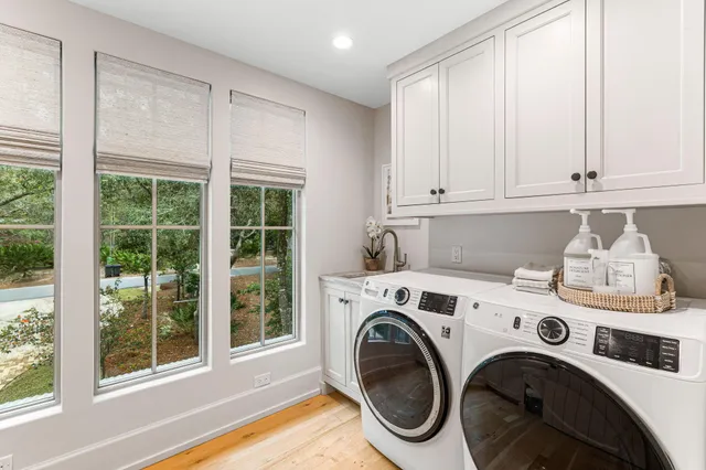 a kitchen with white cabinets and a wooden floor