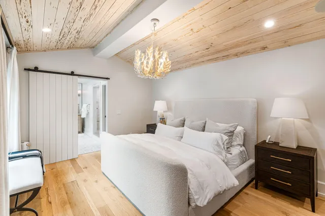 a living room with stainless steel appliances furniture a flat screen tv and a refrigerator