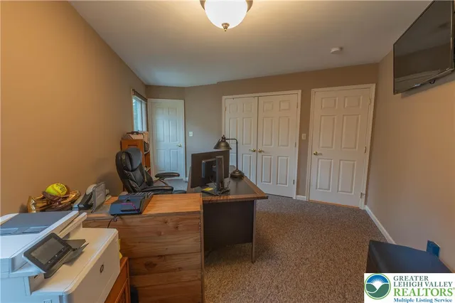 a view of a workspace with furniture and a window